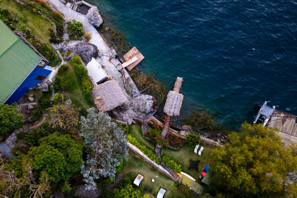 Aerial view of Villas B'alam Ya lakefront property with docks and lush greenery.